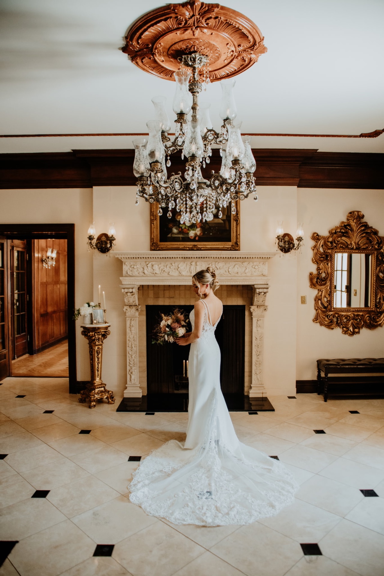 Bride in the grand foyer beneath the crystal chandelier