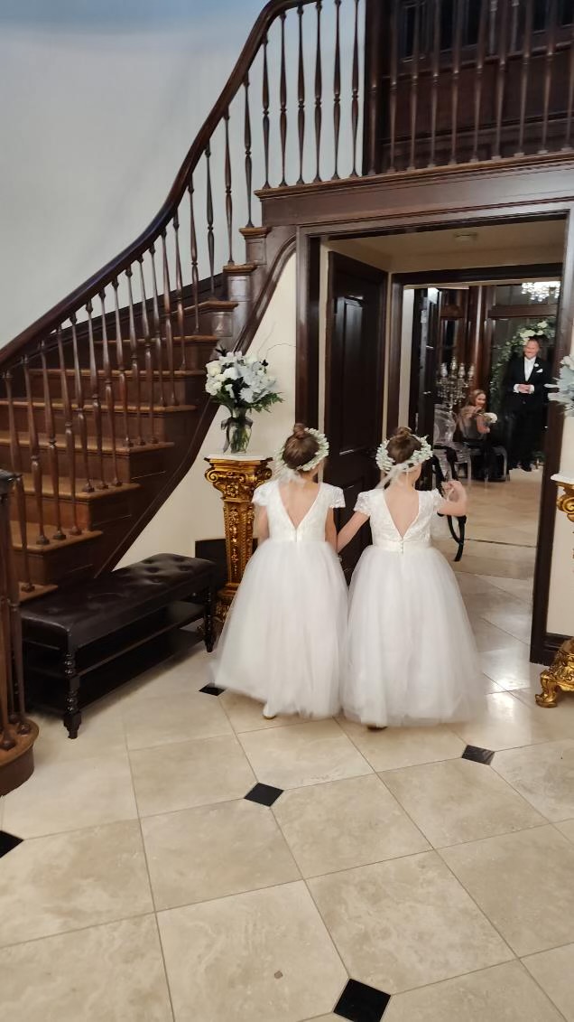 Flower girls entering the mansion's grand foyer
